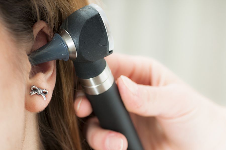 medico controllo orecchio del paziente con otoscopio